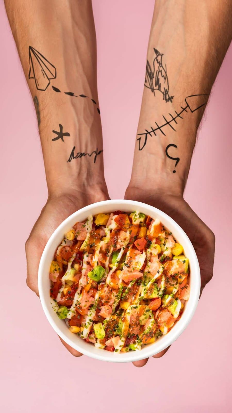 Two hands holding a Made To Chill poké bowl